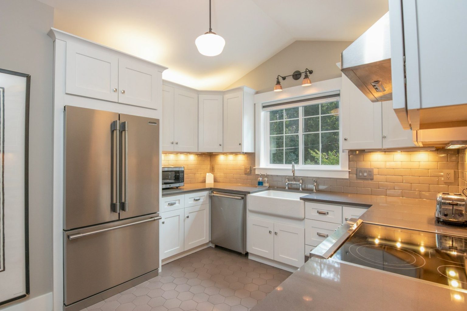 Photo by Clay Elliot white wooden kitchen cabinet and white pendant lamp