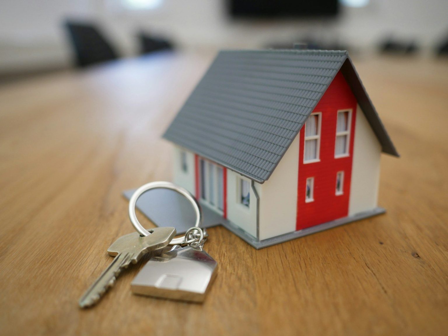 Photo by Tierra Mallorca white and red wooden house miniature on brown table